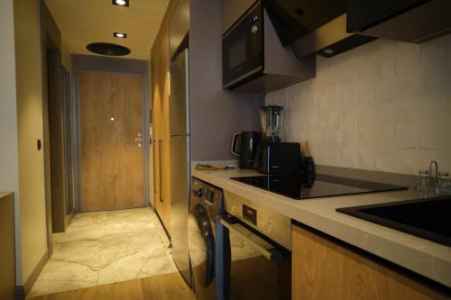 a kitchen with a counter and a door to a hallway at The Diamond In City Luxury Suites By ZENORA Living in Accra