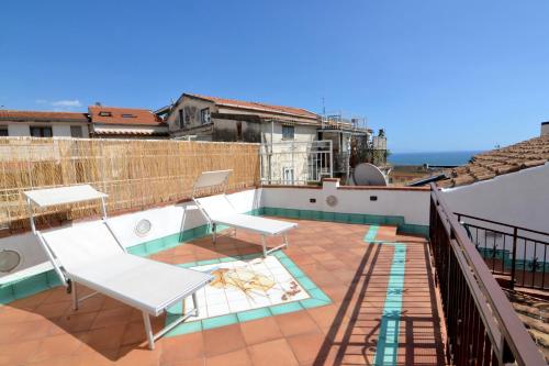 a balcony with a table and chairs on a roof at Dalla torre al mare in Vietri sul Mare