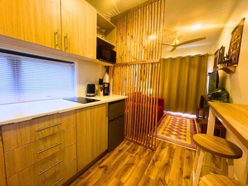a kitchen with wooden cabinets and a wooden floor at The Zanzibar Beach House-South in Bwejuu