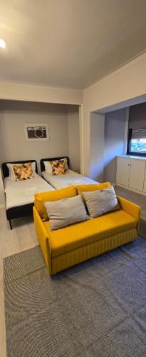 a bedroom with two beds and a yellow couch at DREAM HOUSE 2 Montes Burgos PORTO in Porto