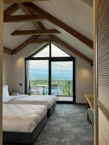 two beds in a room with a large window at Charlton Estate in Yablunytsya