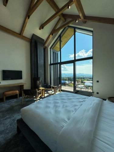a bedroom with a large bed and a large window at Charlton Estate in Yablunytsya