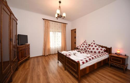 ハツェグにあるCasa Paraのベッドルーム1室(赤と白の枕が備わるベッド1台付)