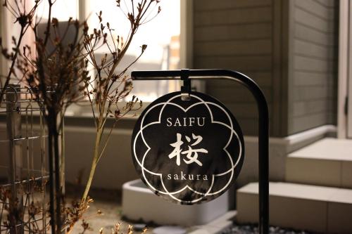 a sign in front of a house with a plant at Saifu Sakura - Vacation STAY 51797v in Dazaifu