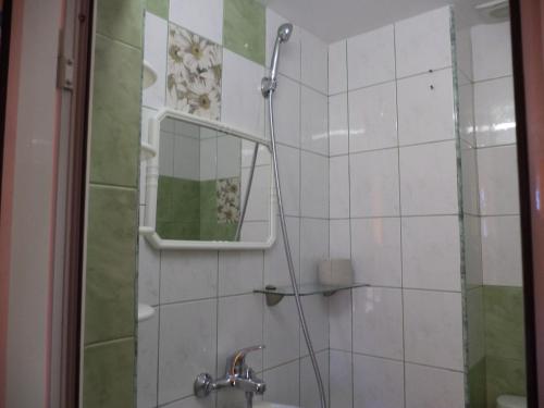 a bathroom with a shower with a mirror and a sink at Guest house Stoyanovi in Chernomorets