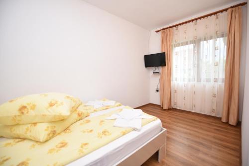 ハツェグにあるCasa Paraのベッドルーム1室(黄色いシーツ付きのベッド1台、窓付)