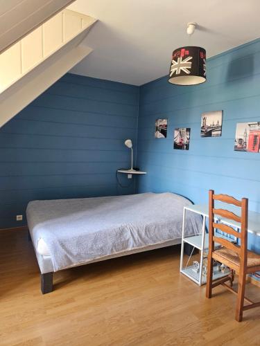 にあるCharmante maison de campagneのベッドと木製の椅子のある青い寝室