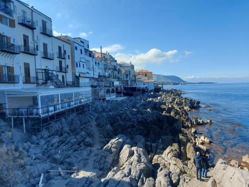 a person standing on the rocks near the water at Giannina House 22 in Cefalù