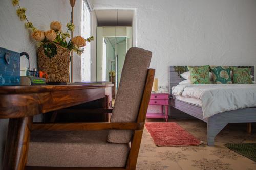 a bedroom with a desk and a bed and a table at Baagh-Bohemian 6BHK Farmhouse, Jagatpura, Jaipur in Jaipur
