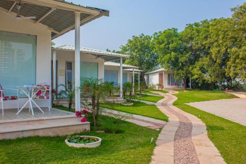 a house with a walkway next to a yard at Baagh-Bohemian 6BHK Farmhouse, Jagatpura, Jaipur in Jaipur