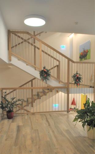 an empty room with a staircase with potted plants at Hotel Mauernböck in Rottenbach