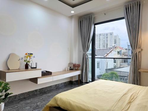 a bedroom with a bed and a large window at Four P Stay Phu Nhuan in Ho Chi Minh City