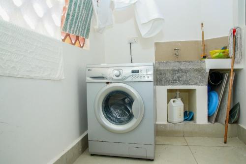a washing machine sitting in a laundry room at Shanzu Beach Homes Mombasa in Mombasa