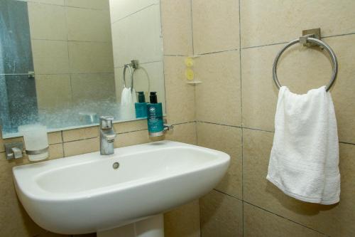a bathroom with a white sink and a mirror at Shanzu Beach Homes Mombasa in Mombasa