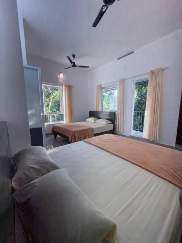a large bedroom with two beds and two windows at Eve's Residency in Meppādi