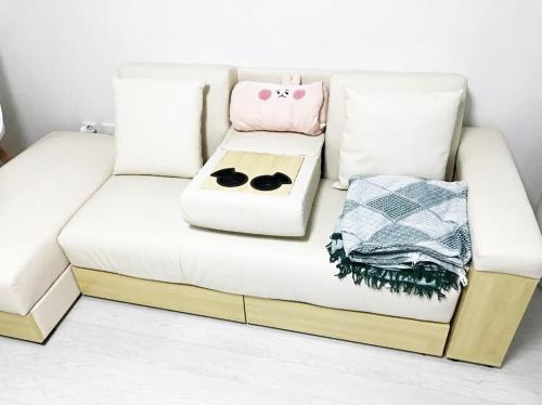 a white couch with two bowls on top of it at Daegu 3 rooms APT All furnished Near downtown & Dongdaegu station in Daegu