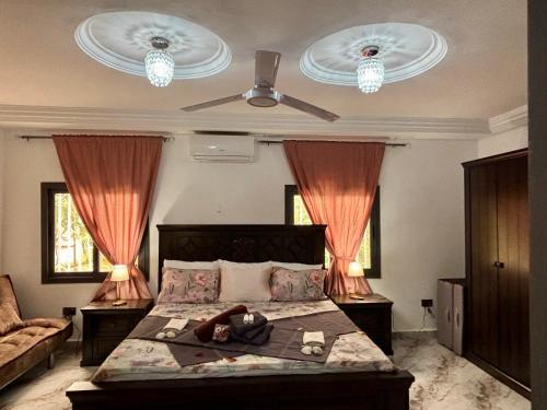 a bedroom with a bed with a teddy bear laying on it at The Gambian Princess in Sukuta