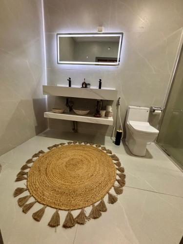 a bathroom with a toilet and a rug on the floor at The Gambian Princess in Sukuta
