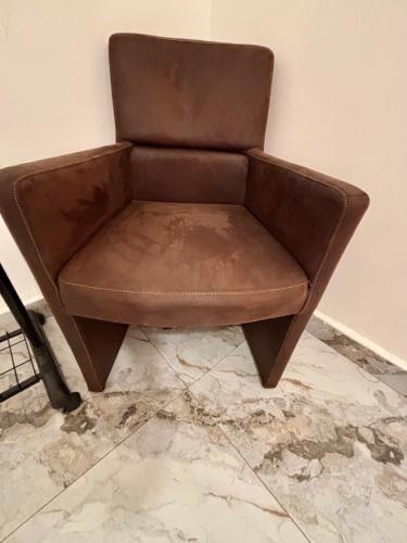 a brown leather chair sitting next to a wall at The Gambian Princess in Sukuta