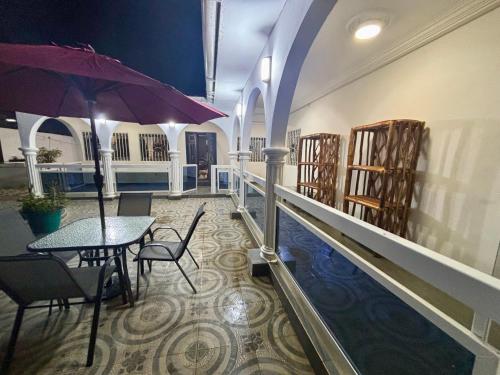 a room with a table and an umbrella next to a pool at The Gambian Princess in Sukuta