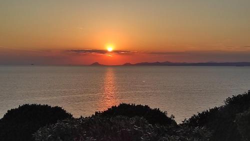 a sunset over the ocean with the sun in the sky at Villa Heliophilia in Koundouros