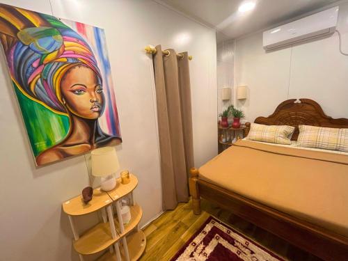 een slaapkamer met een schilderij van een vrouw aan de muur bij The Zanzibar Beach House-North in Bwejuu