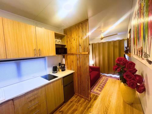 een keuken met houten kasten en een vaas met rozen bij The Zanzibar Beach House-North in Bwejuu