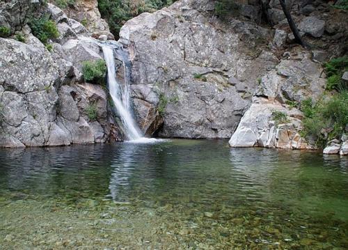 a waterfall on the side of a rocky mountain with water at Le Cabrials in Le Poujol-sur-Orb