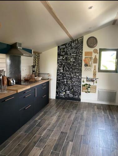 eine Küche mit blauen Schränken und einer schwarzen Wand in der Unterkunft Appartement proche des plages in Bidart