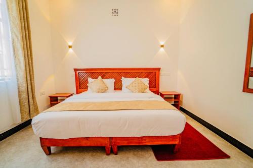a bedroom with a large bed with two night stands at Maasai Villa in Arusha