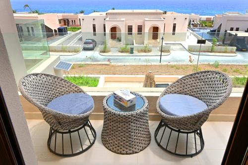 a balcony with two chairs and a table and a window at Wateera Jebel Sifah in As Sīfah