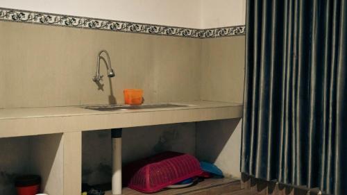a bathroom with a sink and a shower curtain at Lalinggo Bungalow in Tetebatu