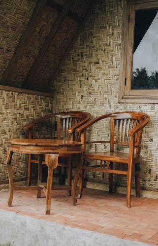 two wooden benches sitting next to a brick wall at Lalinggo Bungalow in Tetebatu