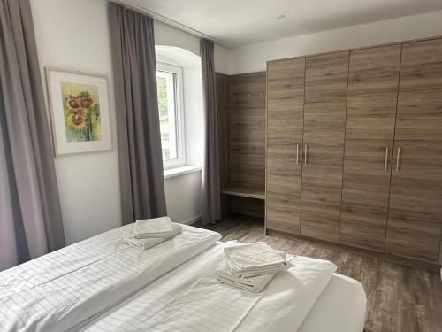 a bedroom with two beds and wooden cabinets at Appartements Marlene in Maishofen
