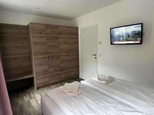 a bedroom with a bed and a flat screen tv at Appartements Marlene in Maishofen