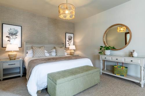 a bedroom with a large bed and a mirror at SEASENSE Boutique Beach Villa in Wilderness