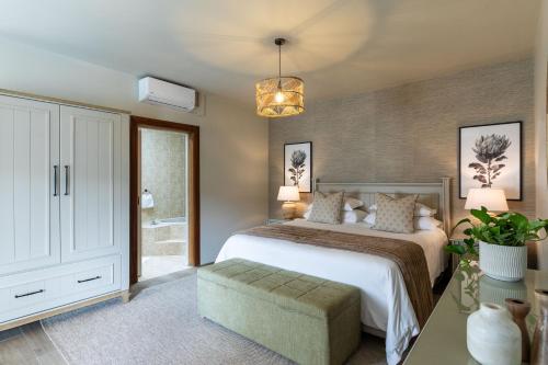 a bedroom with a large bed and a potted plant at SEASENSE Boutique Beach Villa in Wilderness