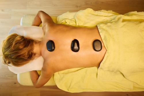 a shirtless child laying in a bed withooky eyes at Hotel Fischerwirt Natur WaldSPA in Faistenau