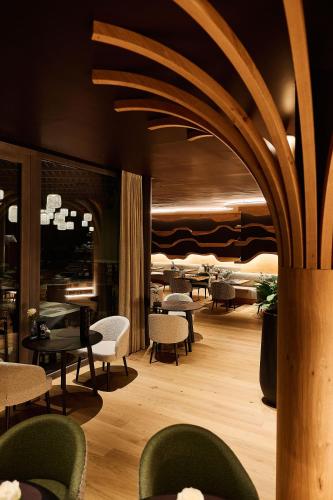 a restaurant with tables and chairs in a room at Hotel Fischerwirt Natur WaldSPA in Faistenau