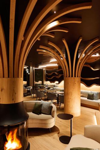 a lobby with tables and chairs and a fireplace at Hotel Fischerwirt Natur WaldSPA in Faistenau