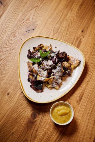 a plate of food on a wooden table at Hotel Fischerwirt Natur WaldSPA in Faistenau
