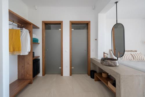 a bathroom with a sink and a mirror at Athera Suites Mykonos in Tagou