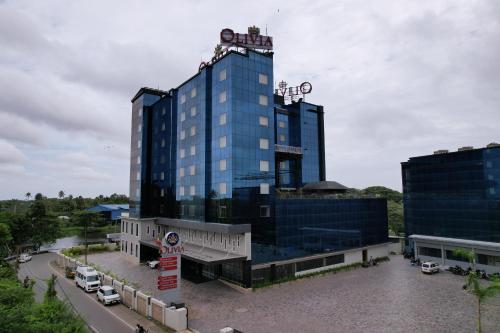 a large glass building with a sign in front of it at Olivia International in Alleppey