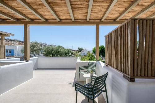 a patio with chairs and a table on a roof at Athera Suites Mykonos in Tagou