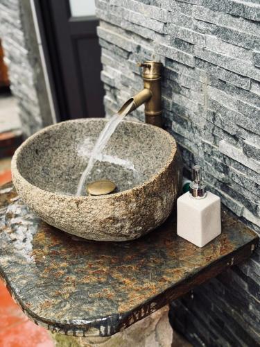 a stone sink with a faucet on a table at Bản Sù - Homestay in Sapa