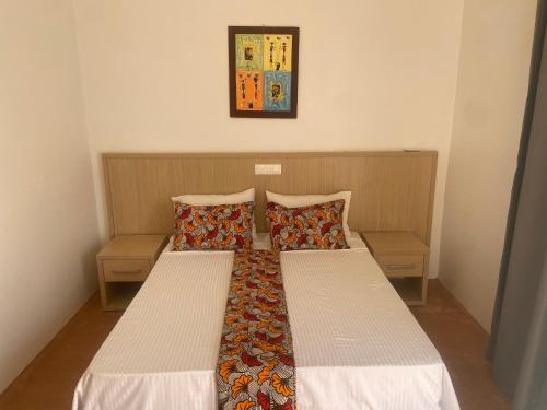a pair of beds in a small bedroom at King baobab lodge in Diakhanor