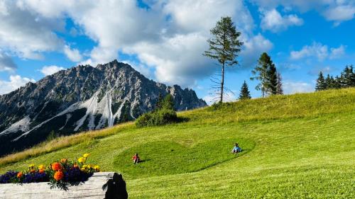 two people on a hill with a mountain in the background at Appartamento Elena in San Nicolò di Comelico
