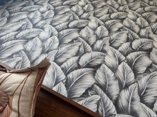 a bedroom with a bed with a pattern of leaves at Heaven hub in Haidar Sāhibgūda