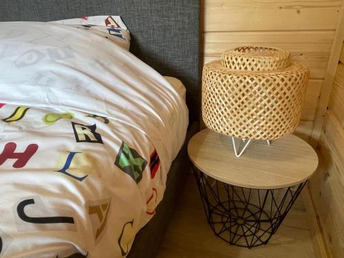 ein Bett mit einem Rattan-Nachttisch neben einem Bett in der Unterkunft Cottage scandinave 89 in Bourbourg