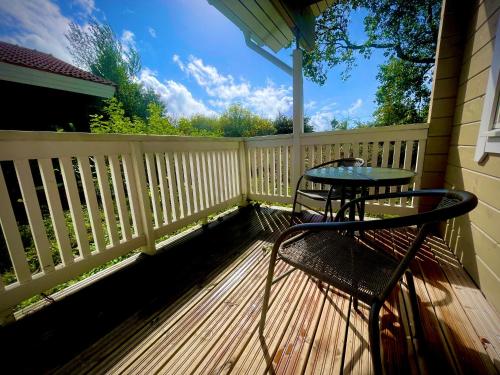 eine Terrasse mit einem Tisch und Stühlen auf einer Holzterrasse in der Unterkunft Cottage scandinave 89 in Bourbourg